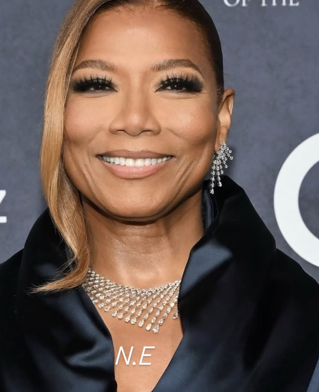 Queen Latifah wearing a deep navy blue garment and a statement diamond collar necklace, illustrating how rich, dark colors and warm-neutral undertones harmonize with the Deep Autumn season.