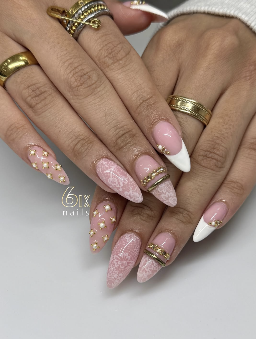 A single accent nail with a white lace pattern and iridescent finish paired with purple French tip nails.