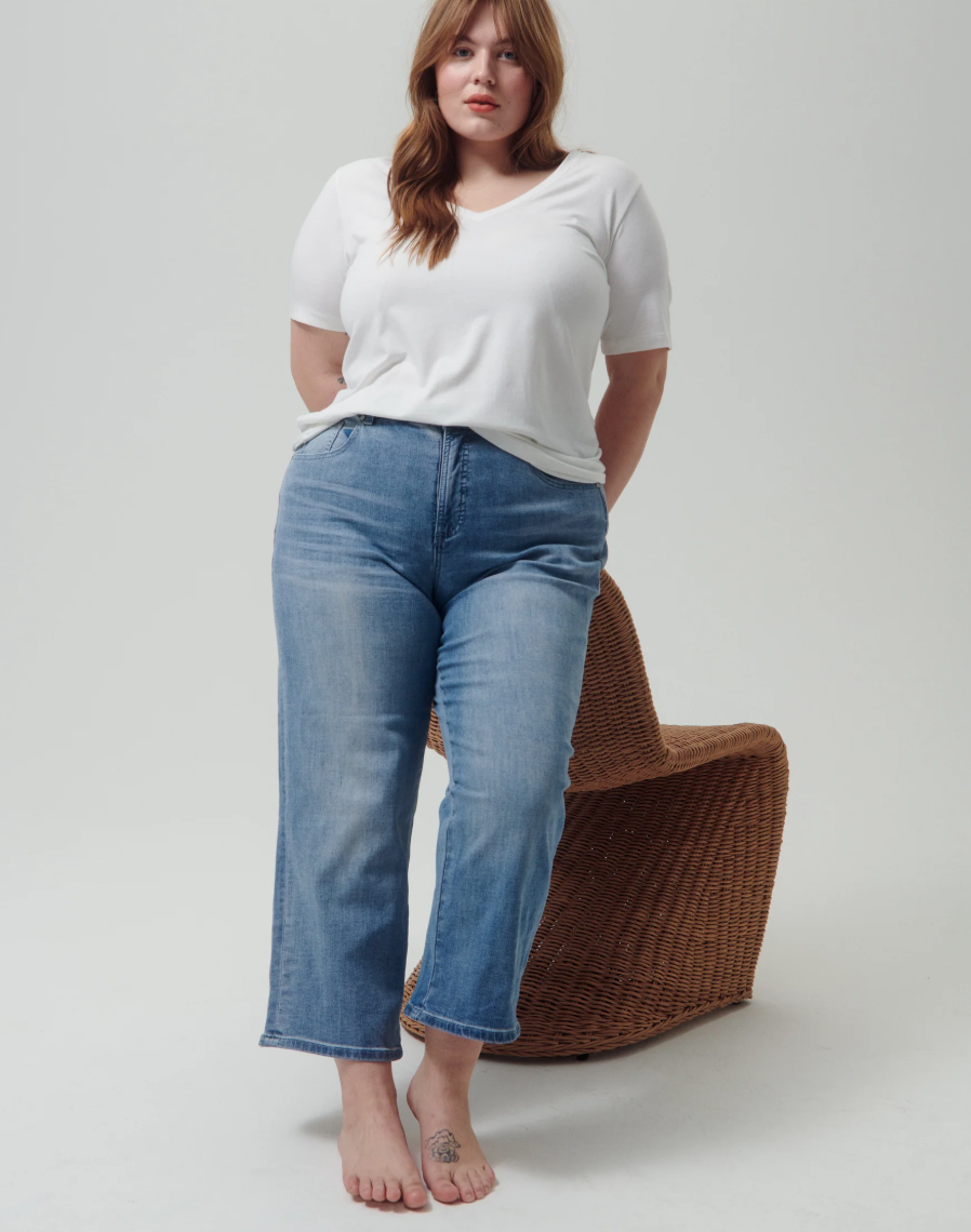 Woman wearing the Universal Standard V-Rex in white, an opaque and inclusive pima cotton V-neck t-shirt.