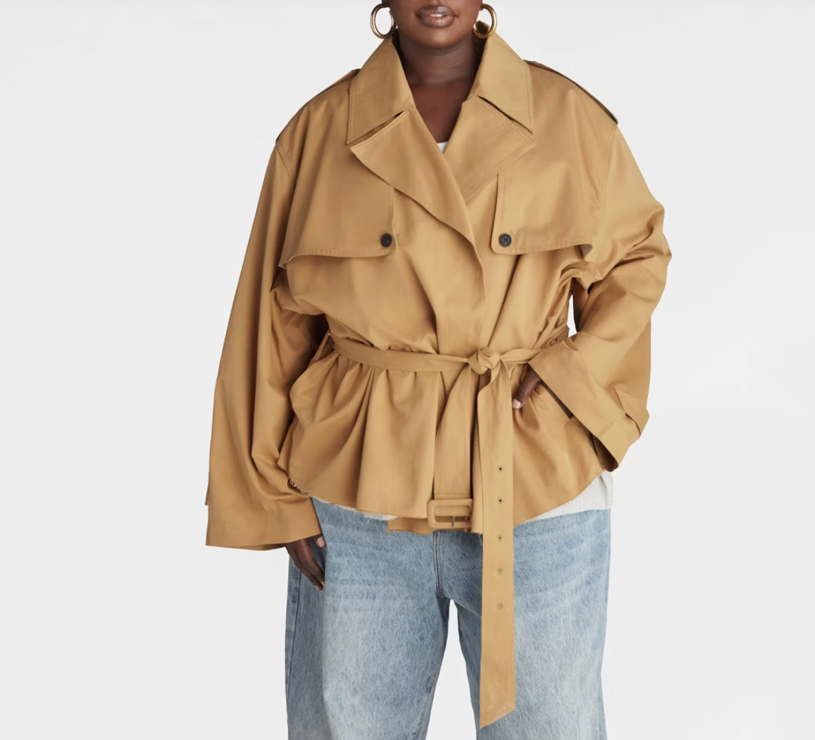 A woman wearing light blue jeans and the KBB by KAHLANA belted cropped trench jacket in a warm tan color.