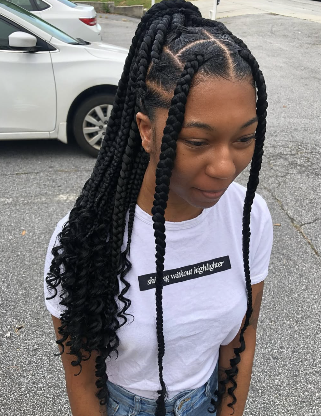 Box braids woven together into one oversized three-strand braid down the back.