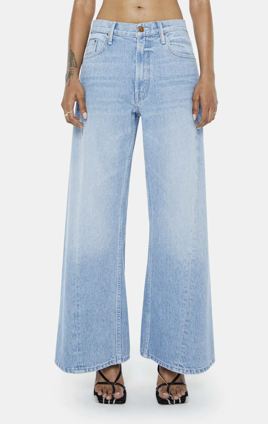 A woman wearing light blue MOTHER Lil Lemon wide-leg jeans with a clean hem, styled with black strappy sandals.