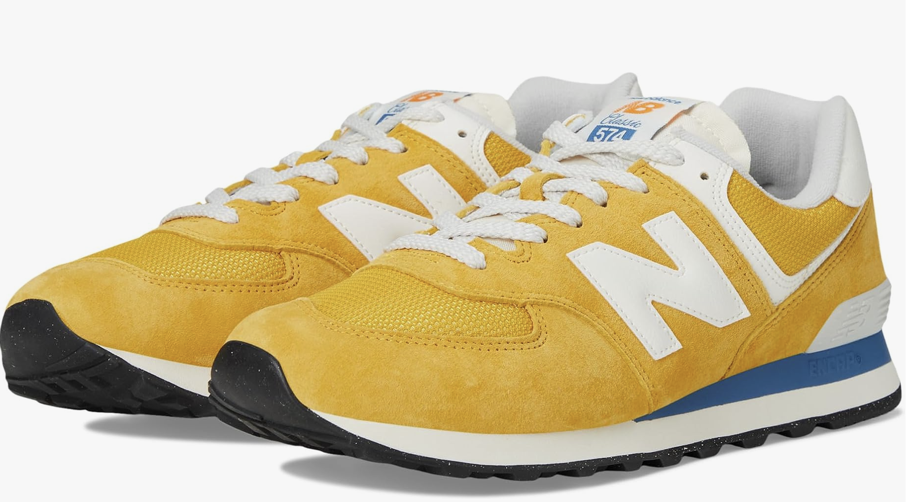A pair of New Balance 574 sneakers in a soft butter yellow suede with white accents, representing the "New Neutral" color trend for a 2026 minimalist capsule wardrobe.