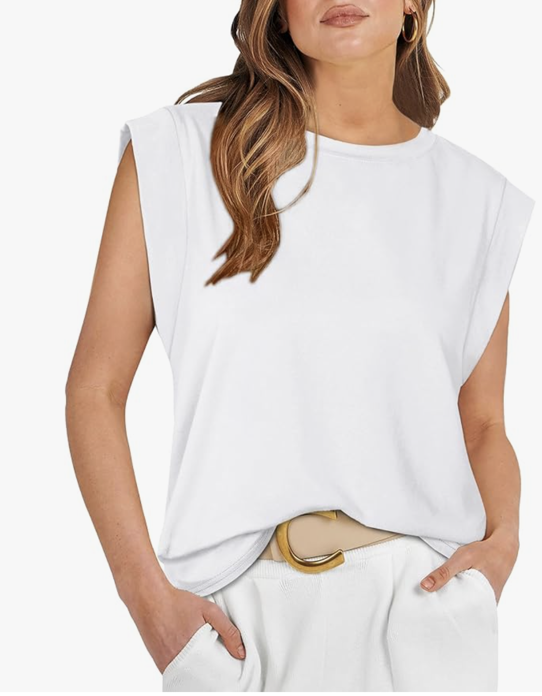 A woman wearing a white cap sleeve muscle t-shirt tucked into a white bottom, styled with a tan belt featuring a gold circular buckle.