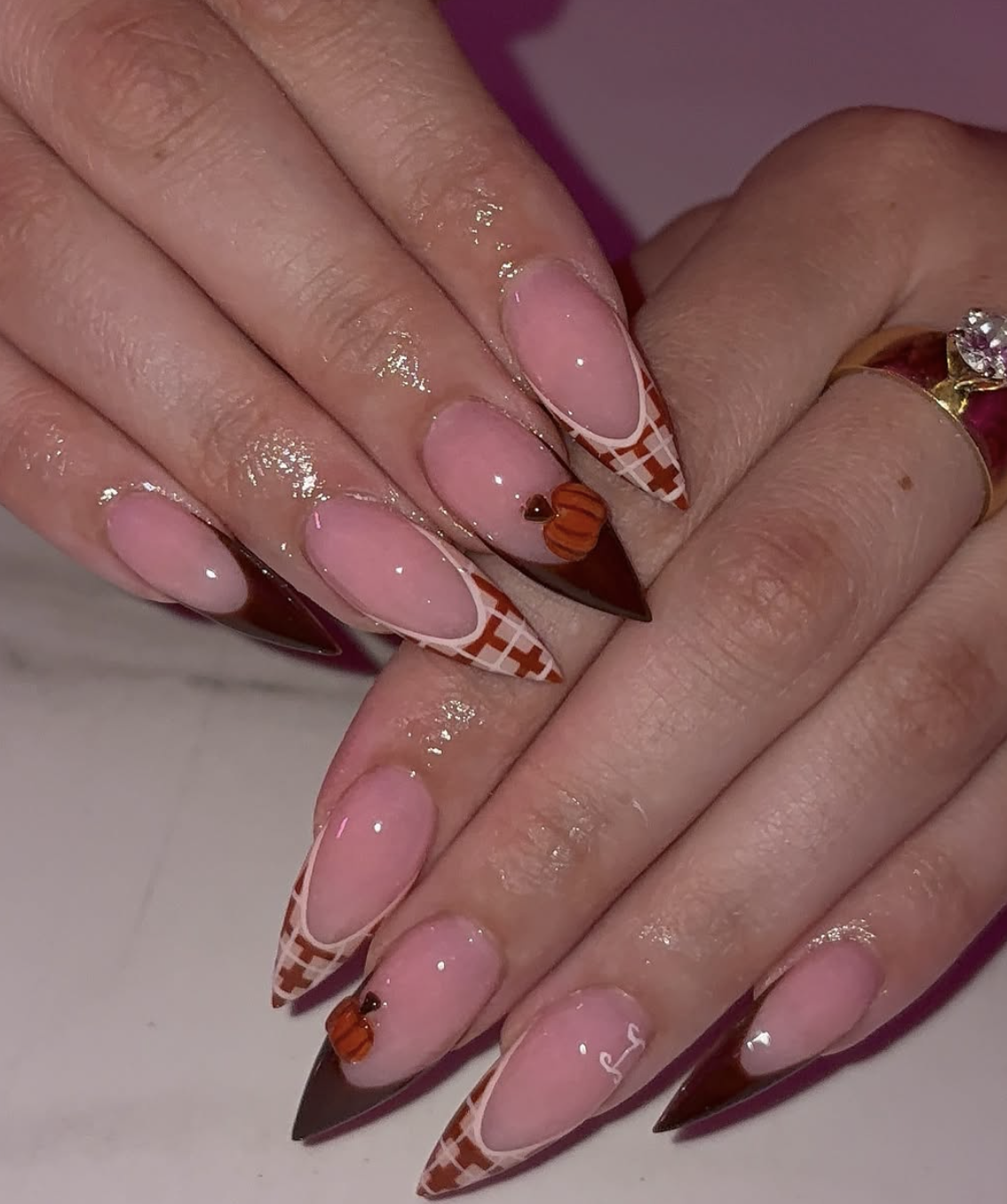 French manicure with small orange pumpkin designs painted along the tips