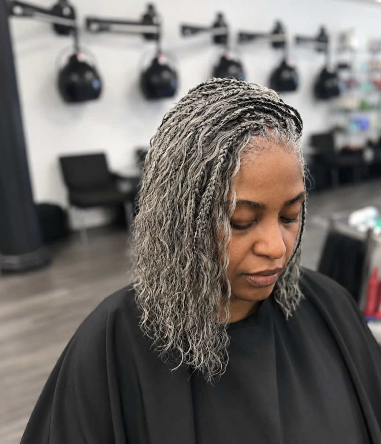 Woman wearing shoulder-length gray mini twists with a side part and softly curled ends.