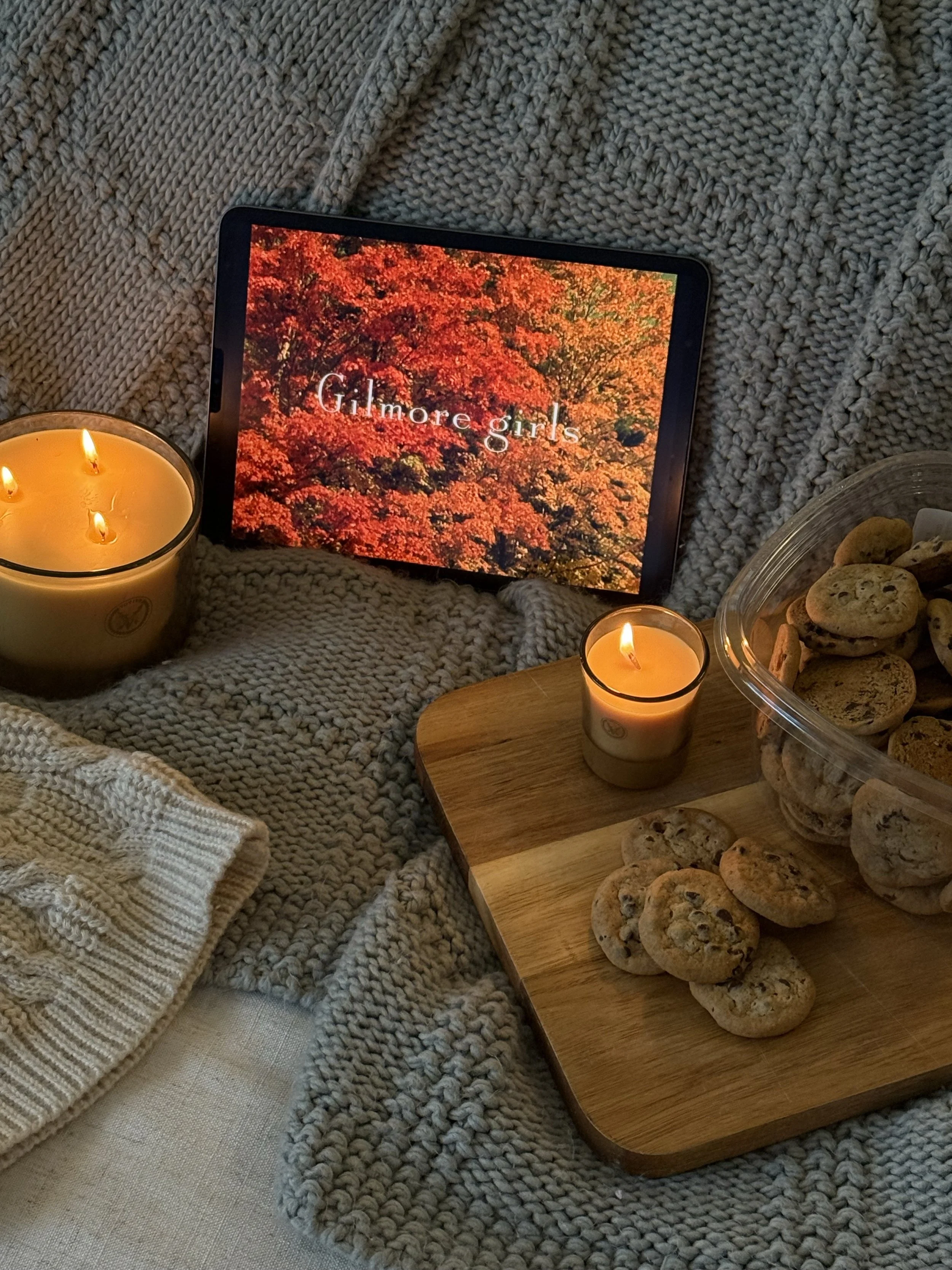 Cozy fall night in with candles, blanket and a book