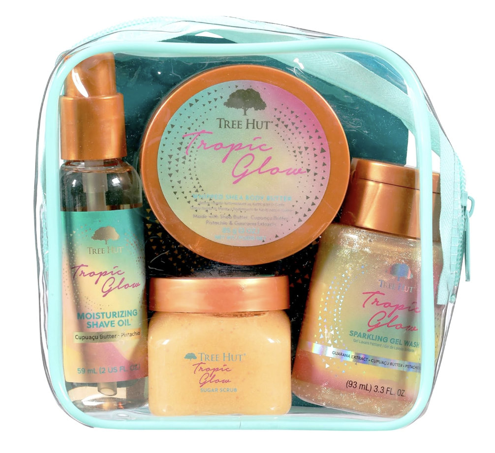 Tree Hut Tropic Glow body care gift set packaged inside a clear zippered travel pouch, featuring shave oil, sugar scrub, body butter, and body wash.