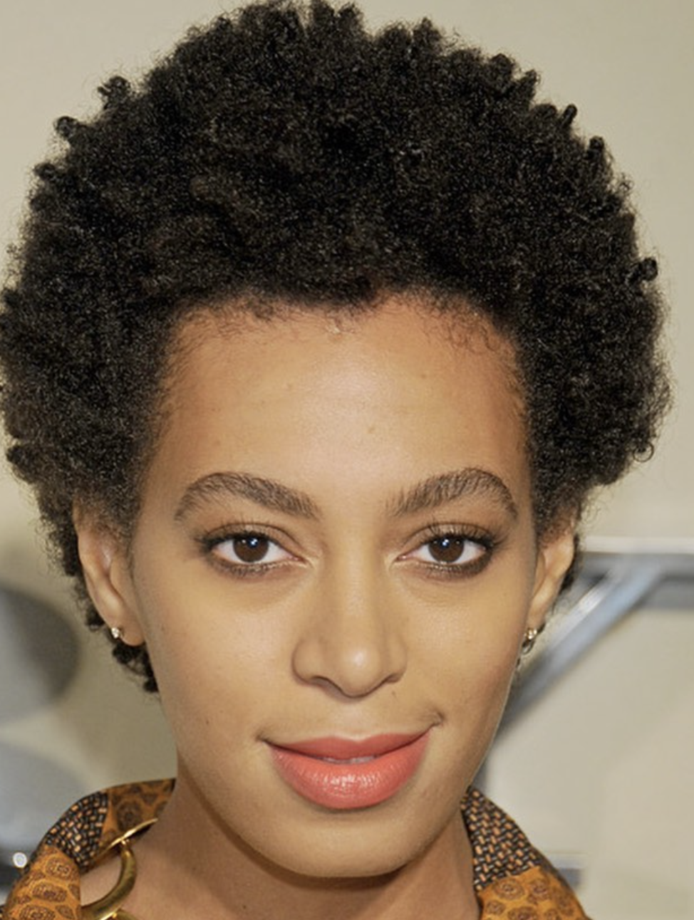 Solange Knowles wearing a teeny weeny afro (TWA) with her natural hair texture to highlight the balanced proportions of an oval face shape.
