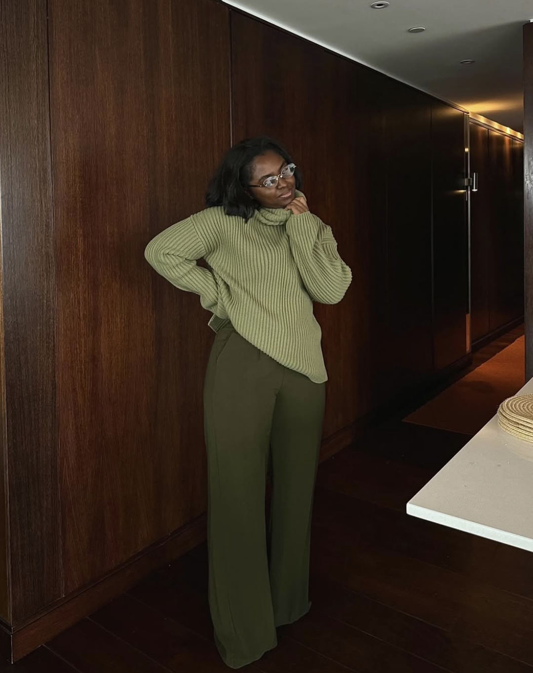 A winter outfit featuring green corduroy pants and a chunky oversized knit sweater.