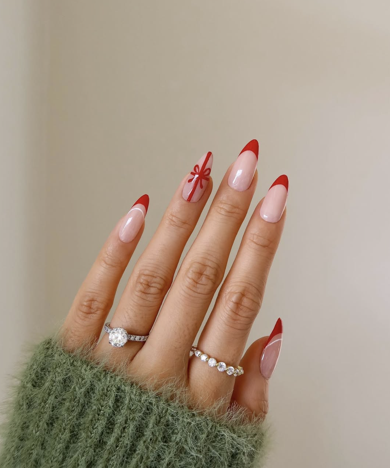 Glossy dark red Christmas nails with a small bow accent nail