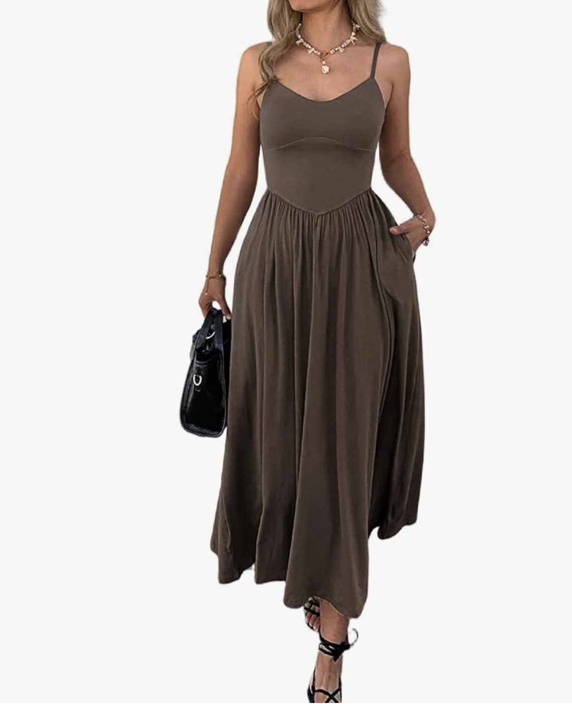 A person wearing a flowy charcoal gray maxi dress styled with a black leather shoulder bag and black strappy low-heeled sandals.