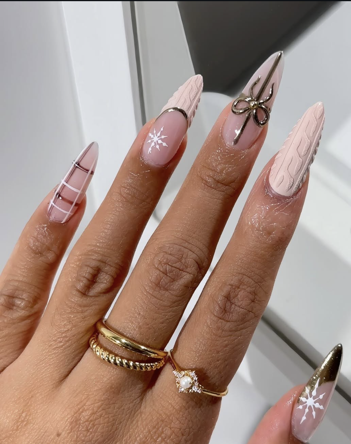 Milky Christmas nails with delicate gold bow accents