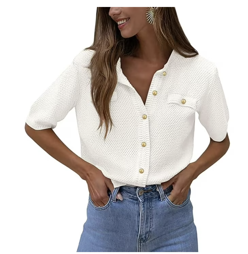 A woman wearing a white short-sleeve knit cardigan with a textured honeycomb pattern and gold-tone buttons, paired with light-wash denim jeans.