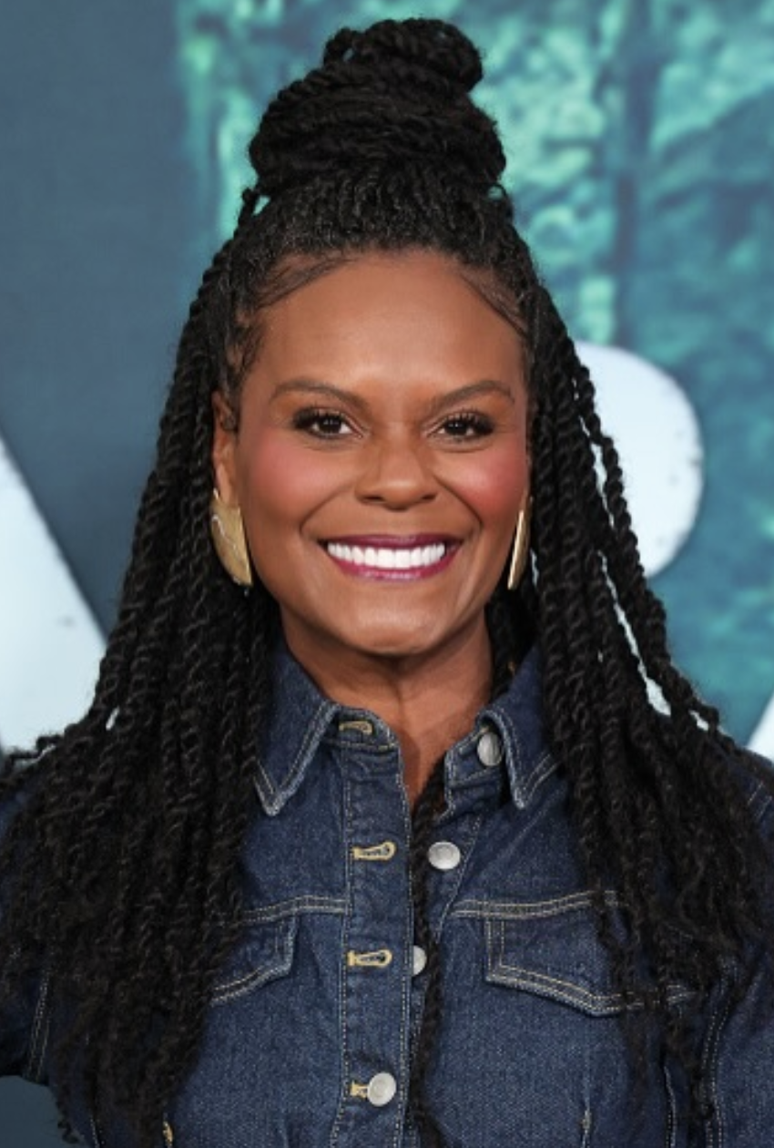 abitha Brown with a square face shape wearing a voluminous half-up kinky twist-out, showing how natural texture and height balance a defined jawline.