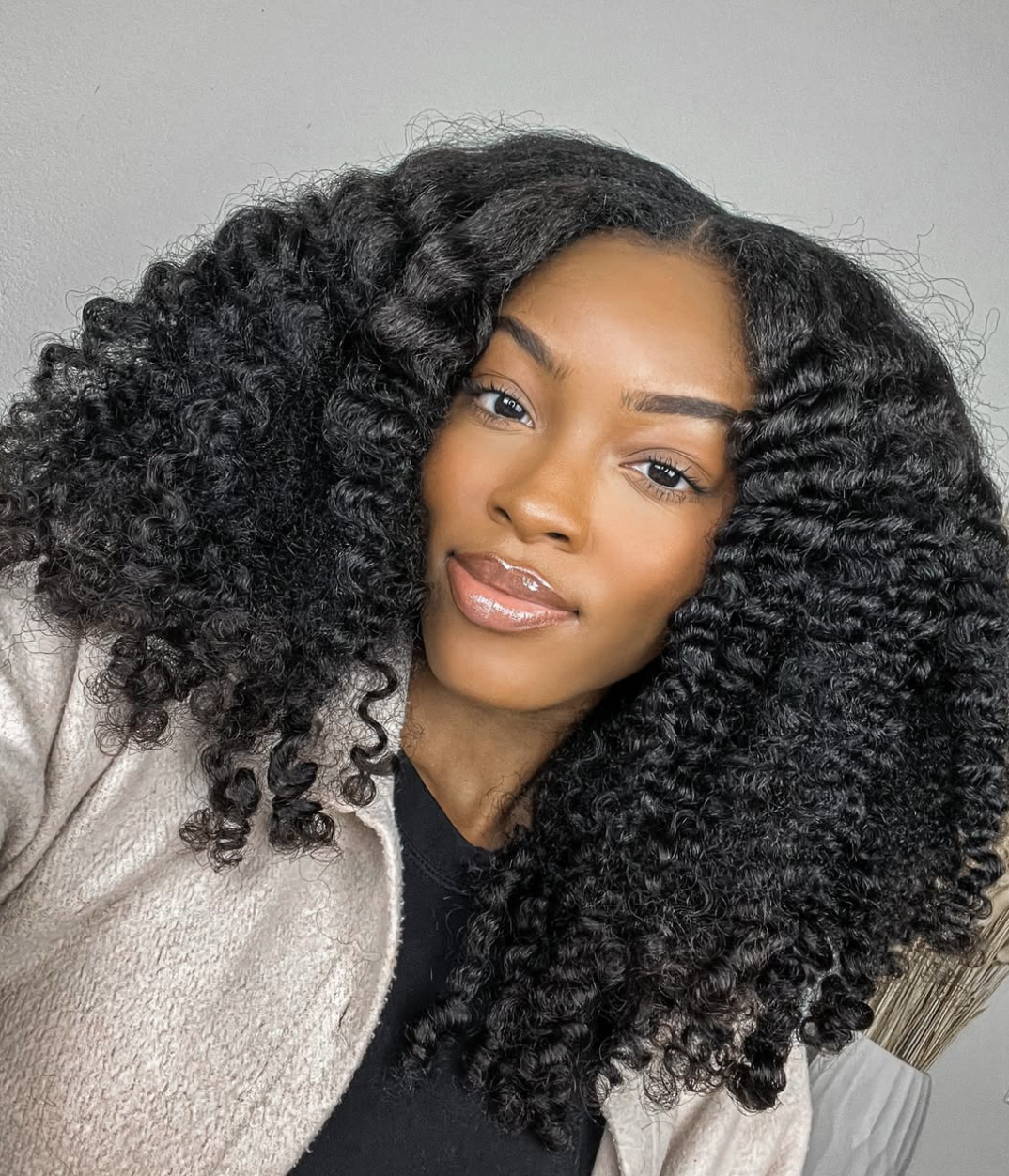 Close-up of a woman with a square face shape sporting a defined, voluminous braid-out that provides soft texture and organic movement."