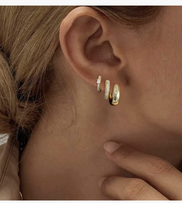 Close up of gold huggie hoop earrings, a trending jewelry staple for a spring 2026 capsule wardrobe.