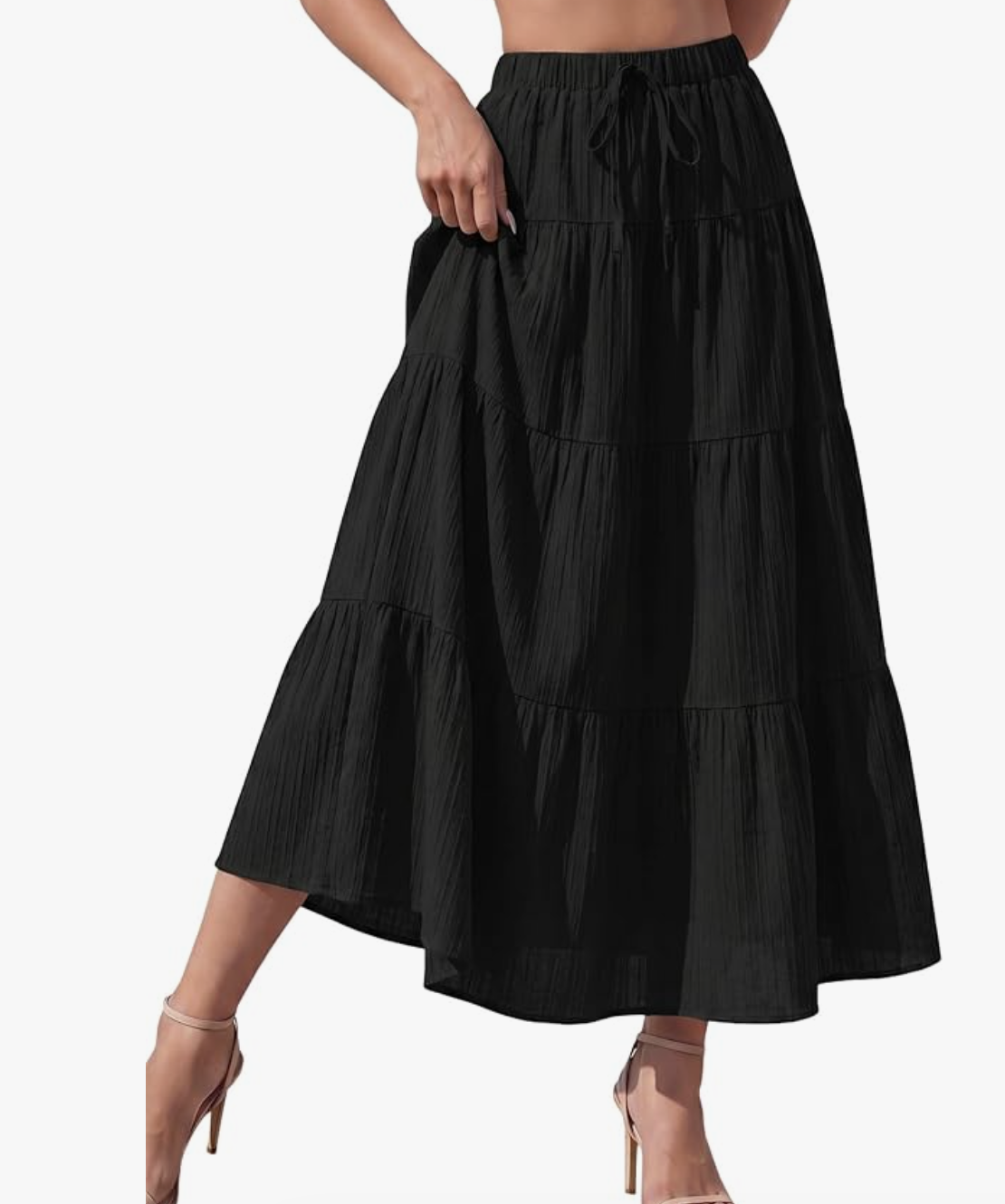 Close-up of a tiered, bohemian-style black cotton maxi skirt featuring a drawstring waist.