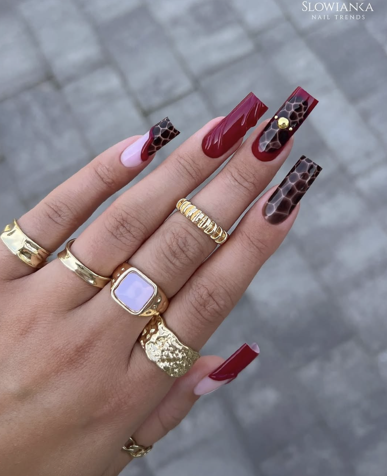 Rosy pink oval nails outlined along the sides and tips with a fine chocolate-brown border.