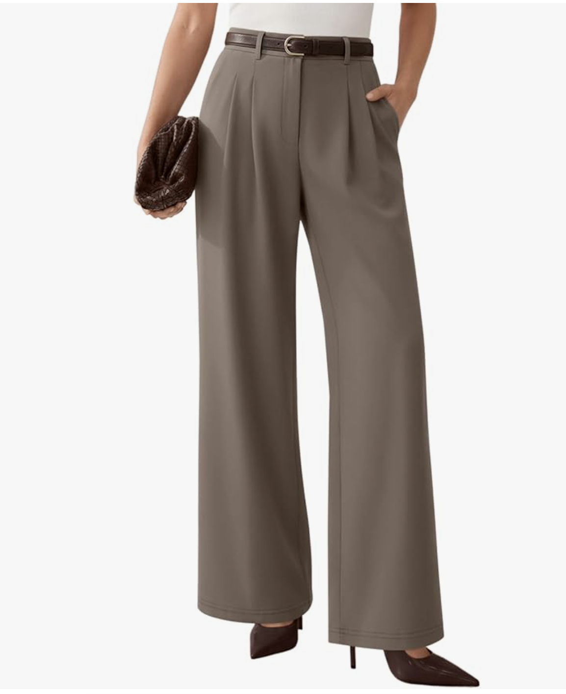 Close-up of a woman wearing high-waisted, straight-leg pull-on trousers in a taupe-brown shade, featuring sharp front pleats and a thin brown leather belt, styled with dark pointed-toe heels.