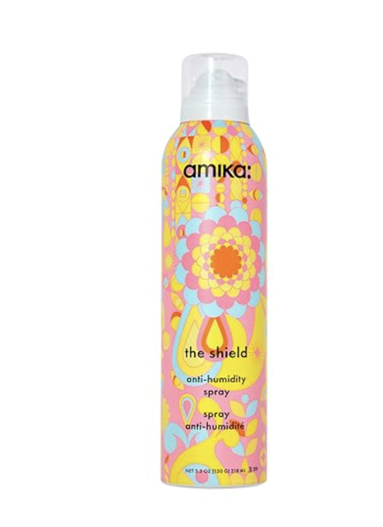 Bottle of amika The Shield anti-humidity spray with colorful pattern packaging.
