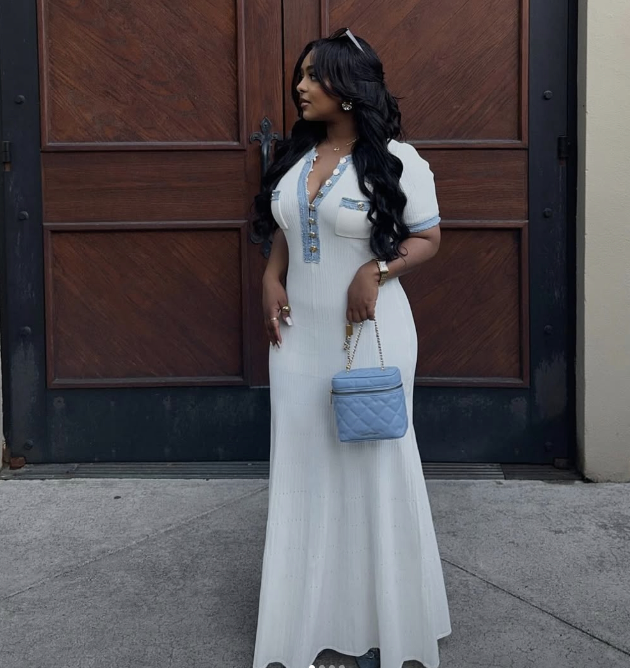 A woman wearing a fitted white and blue bodycon midi dress and nude pointed-toe high-heeled pumps.