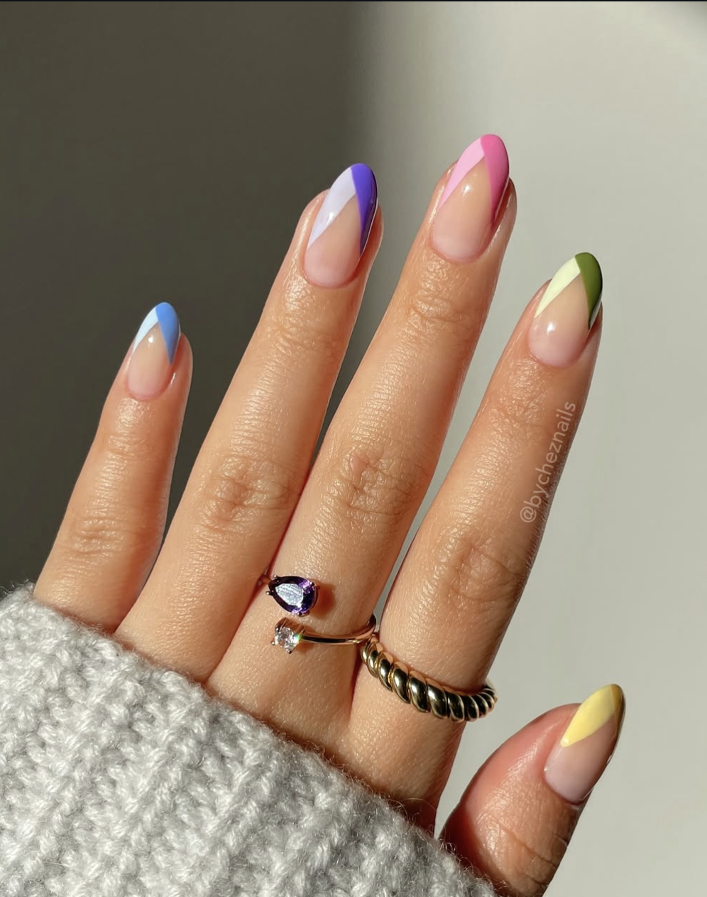 Long, oval-shaped nails with a translucent base coat featuring an abstract, modern split-color French tip design in pastel lavender and sky blue.
