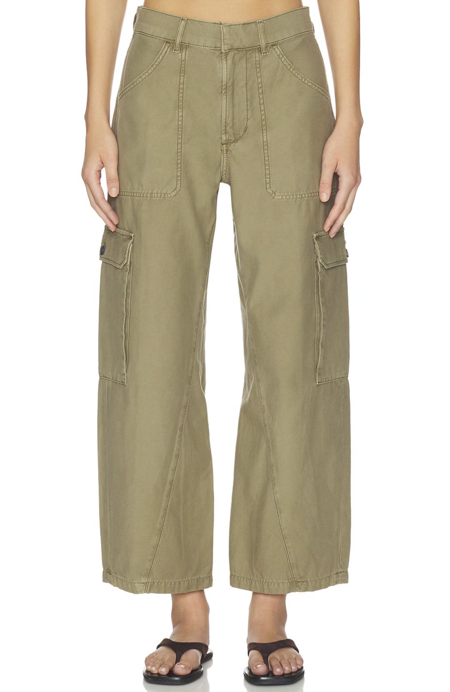 A person wearing high-waisted olive green wide-leg cargo pants with large side utility pockets and brown thong sandals.