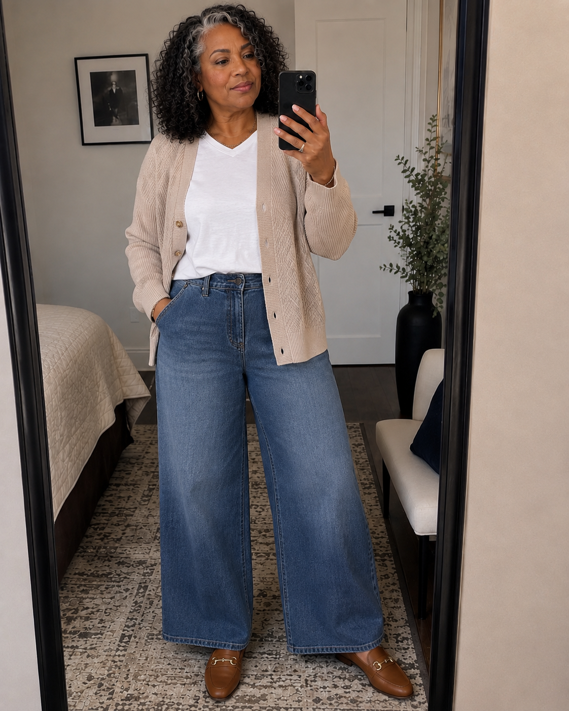 Stylish woman over 50 wearing modern dark-wash jeans with a fitted knit and polished fall accessories.