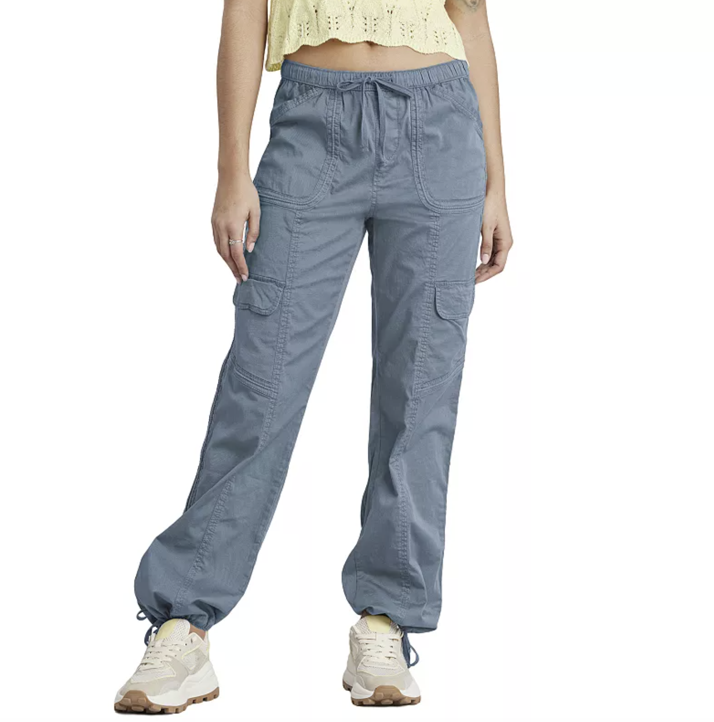 A person wearing light blue high-waisted stretch twill cargo pants with a drawstring waist and elastic cuffs, paired with cream-colored sneakers.