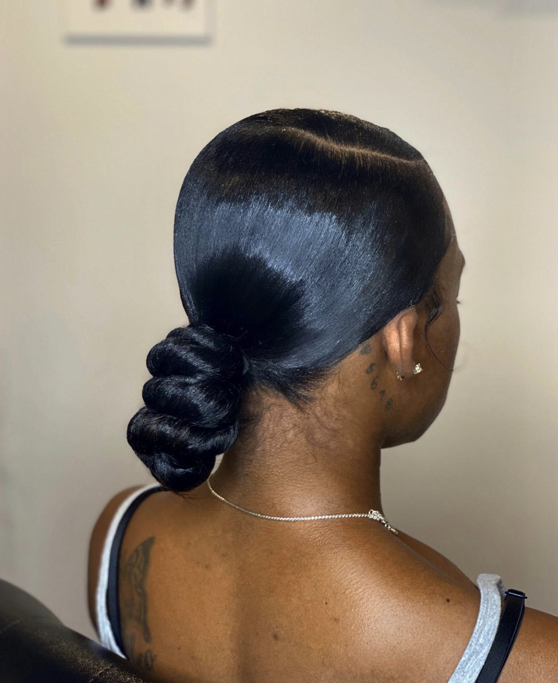 Silk press hair pulled into a low twisted bun at the nape