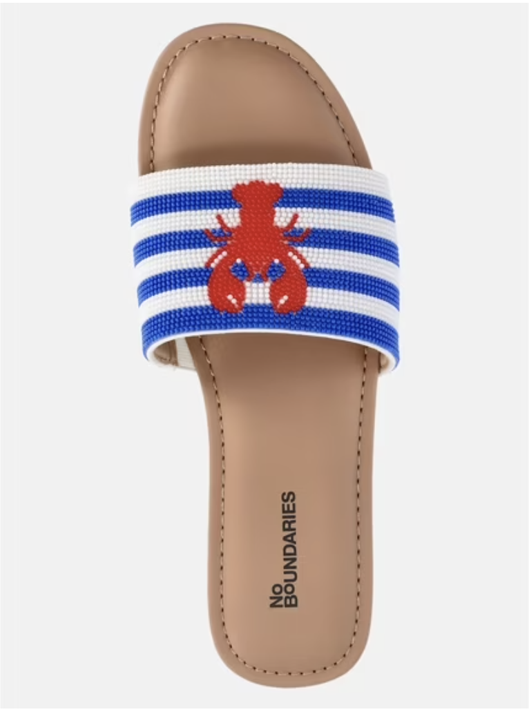 A pair of neutral-toned beaded slide sandals highlighting textured artisan details for summer.