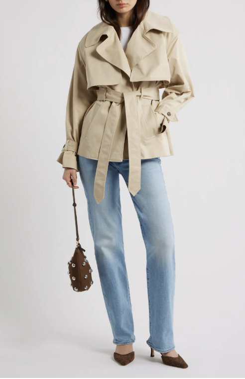 A close-up of the Open Edit Exaggerated Crop Trench Coat in khaki, featuring a belted waist and cropped silhouette, styled with light-wash jeans and brown pointed-toe heels.