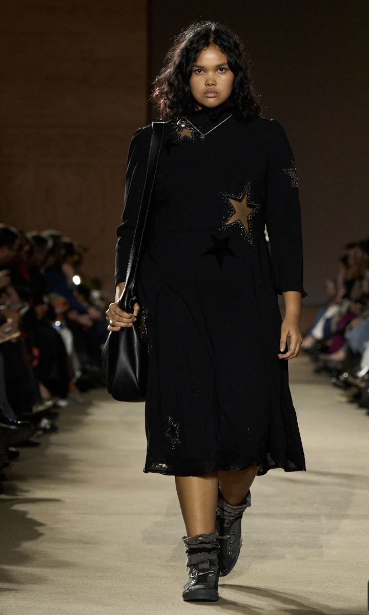 Detail shot from the Coach Fall/Winter 2026 runway showing textured clothing and boots, representing the shift toward gritty, messy-chic fashion and beauty trends.