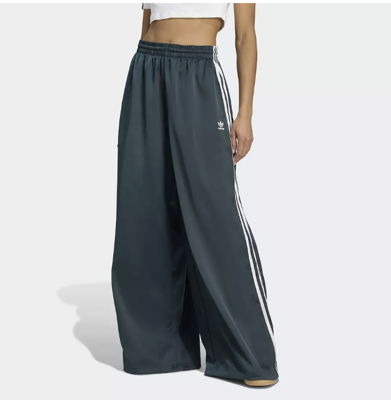 A side view of the [adidas Originals Adicolor Satin Wide Leg Track Pants](https://bit.ly/4cnMP80) in shadow navy, featuring a high-waisted fit, silky satin finish, and white side stripes for a sophisticated Sportif Luxe look.