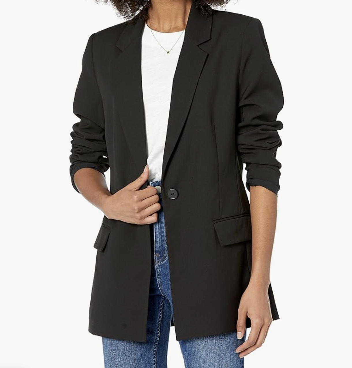 A woman wearing The Drop Blake Long Blazer in black, styled over a white top and straight-leg jeans.