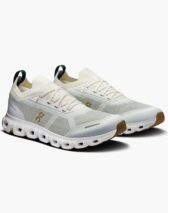 A pair of white and sand-colored On Cloud 6 Versa sneakers, highlighted as the best comfortable work sneakers for long commutes and business-casual offices.