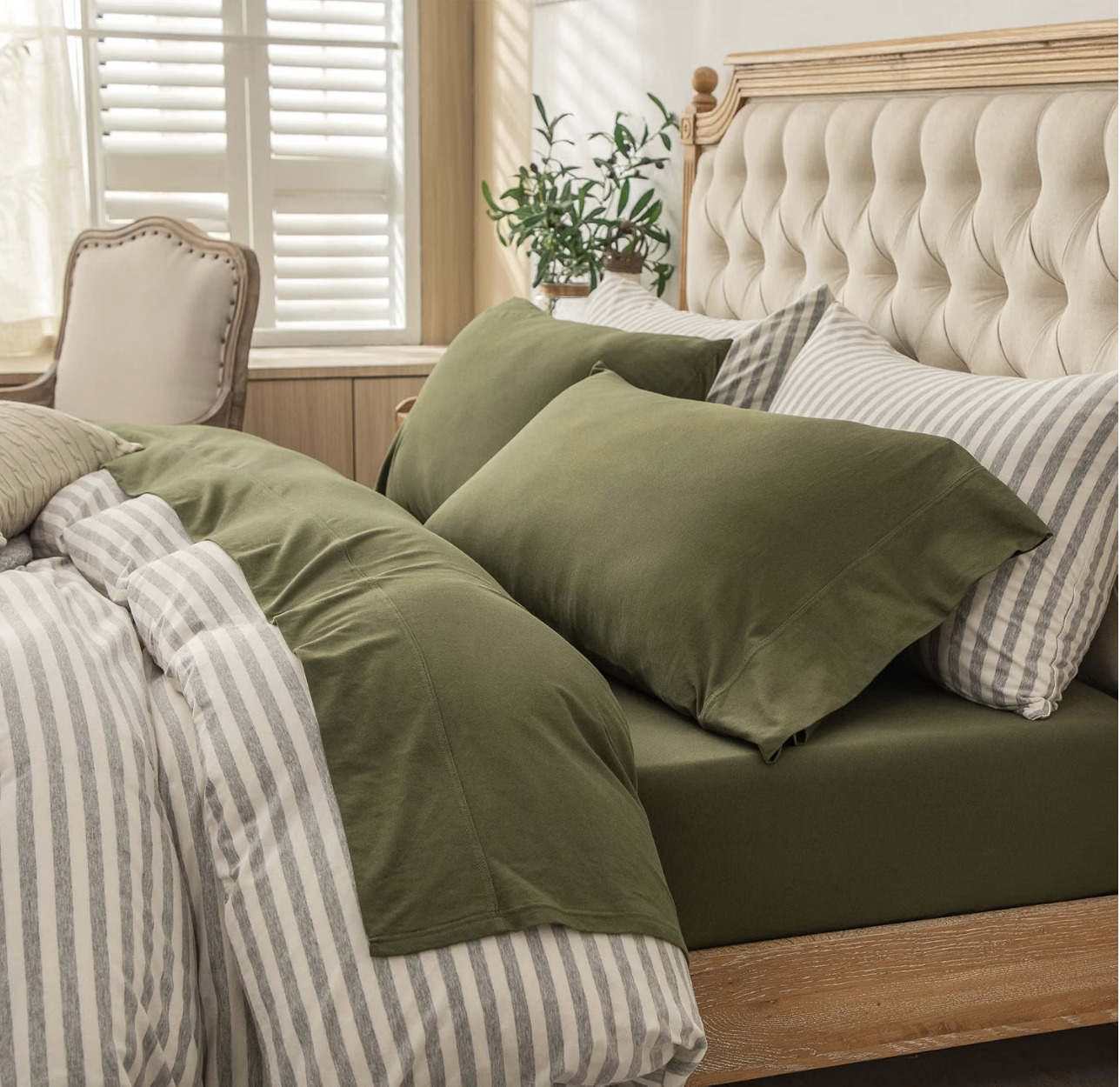 Four-piece jersey knit sheet set on a made bed