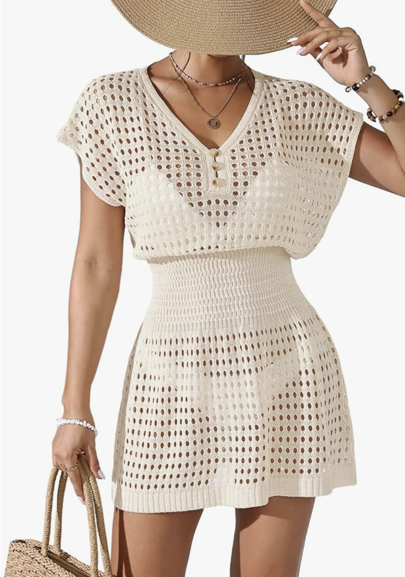 A close-up of a cream-colored crochet swim cover-up featuring a V-neckline, button-front detailing, and a delicate open-knit pattern.