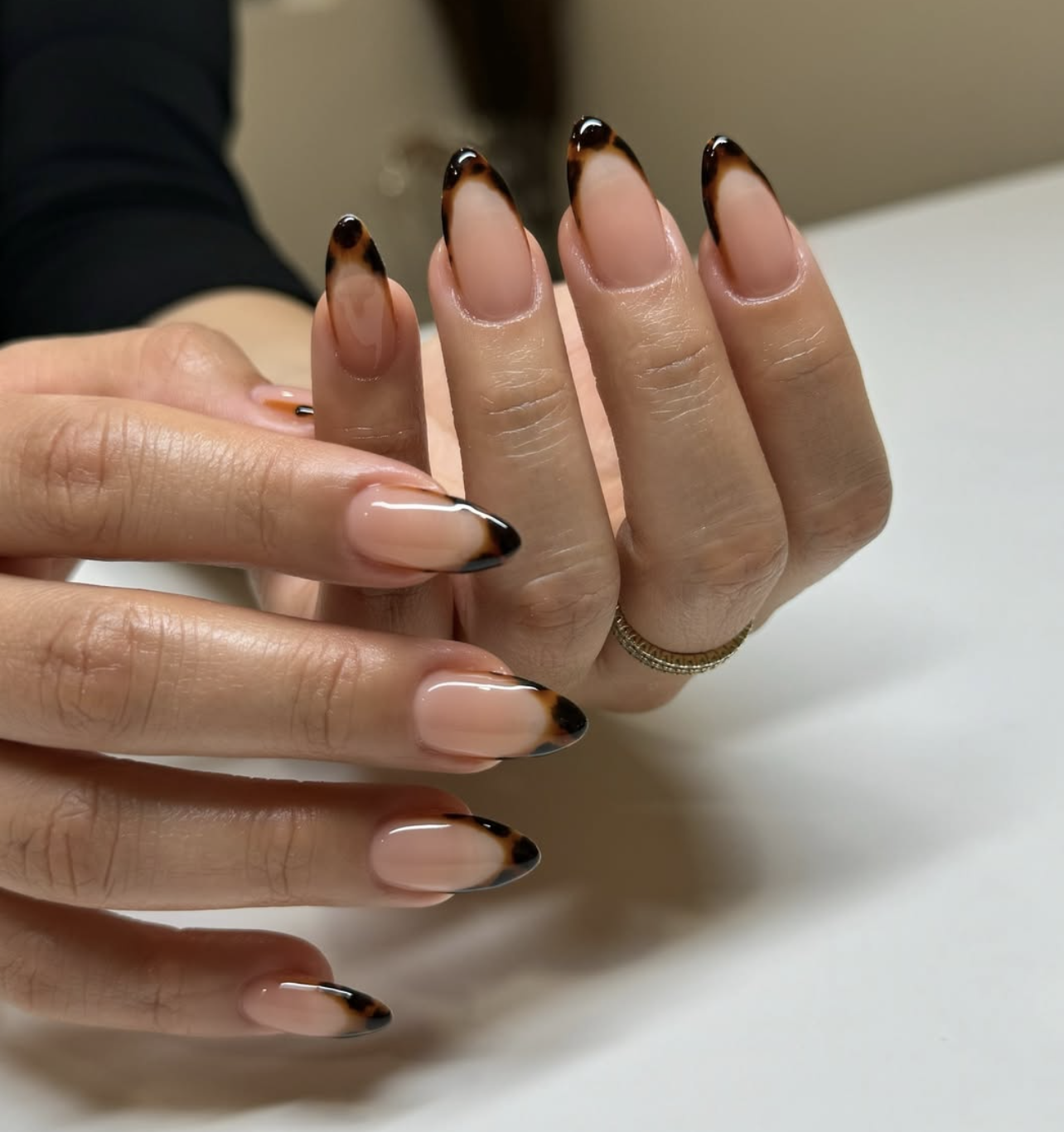 2026 nail trends: Tortoiseshell French tip manicure with deep amber and black tones, a chic and modern animal print twist on a classic design.
