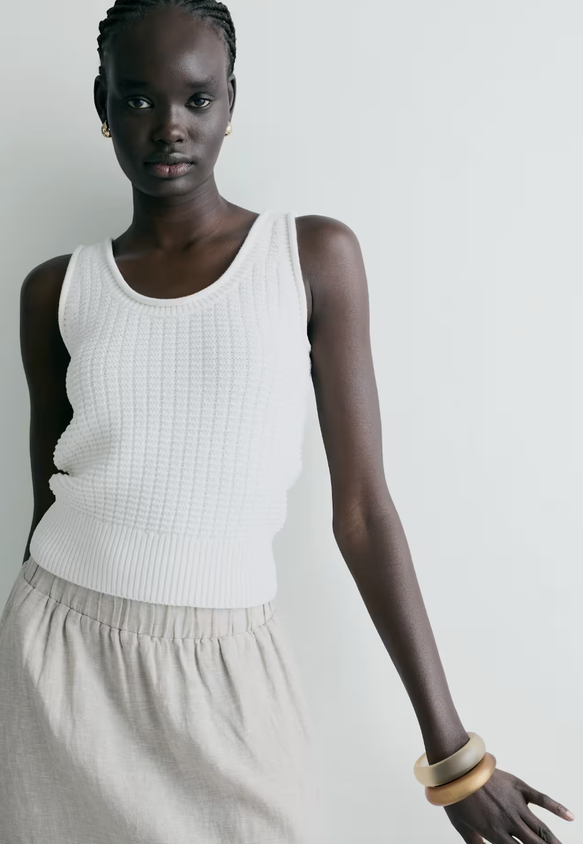 Professional traveler's pick: the Quince Organic Cotton Waffle Cropped Sweater Tank in white, featuring a textured waffle knit and a modern high-neck silhouette.