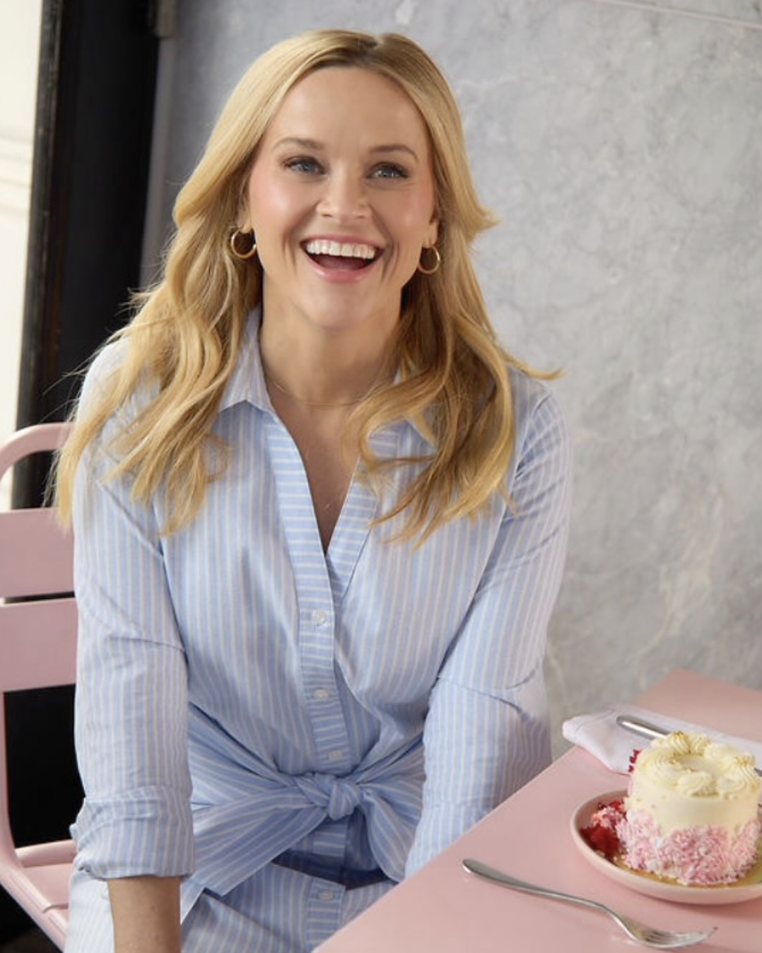 A visual example of a Light Spring palette featuring Reese Witherspoon in a warm light blue pinstripe shirt, illustrating how fresh, sun-lit tones harmonize with warm fair skin and golden hair.