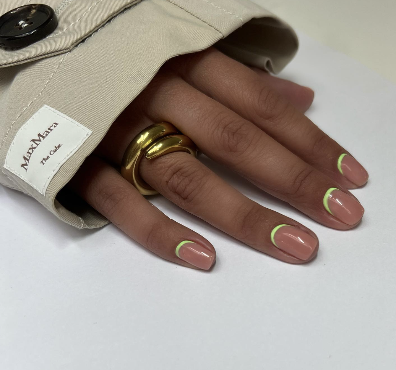 Medium almond-shaped nails with a glossy sheer nude base featuring a minimalist neon lime green outline French tip.