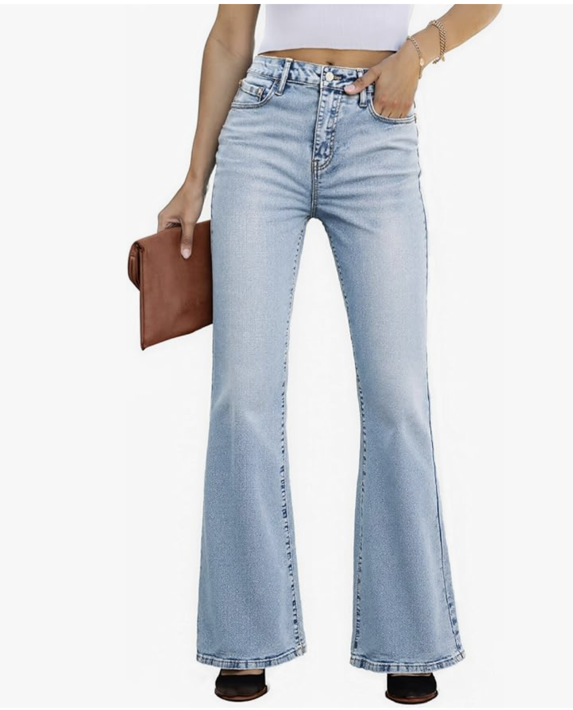 Fashion influencer wearing light wash high-waisted bootcut jeans and holding a brown leather clutch bag.