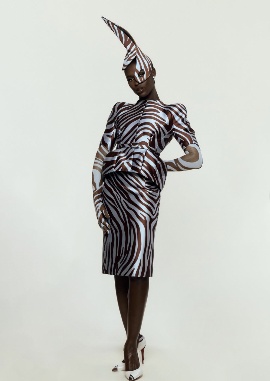 Jodie Turner-Smith at the 2026 Academy Museum Gala in a brown and pale blue zebra-print peplum suit with matching gloves and a sculpted pointed headpiece.