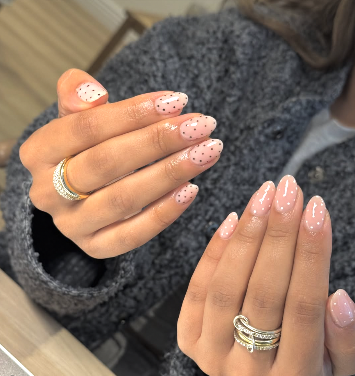 Almond shaped nails with a sheer nude base and various black and white polka dot patterns.