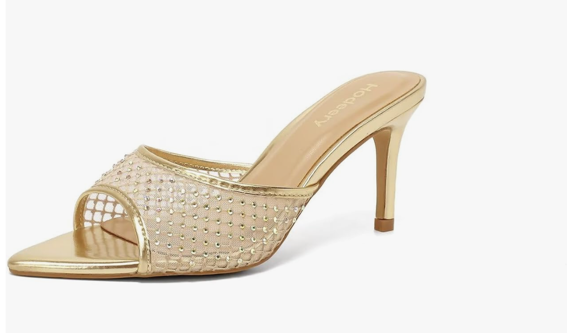 A pair of pointed-toe gold mesh mule heels covered in sparkling rhinestones, styled as a statement evening shoe for a luxury resort vacation.