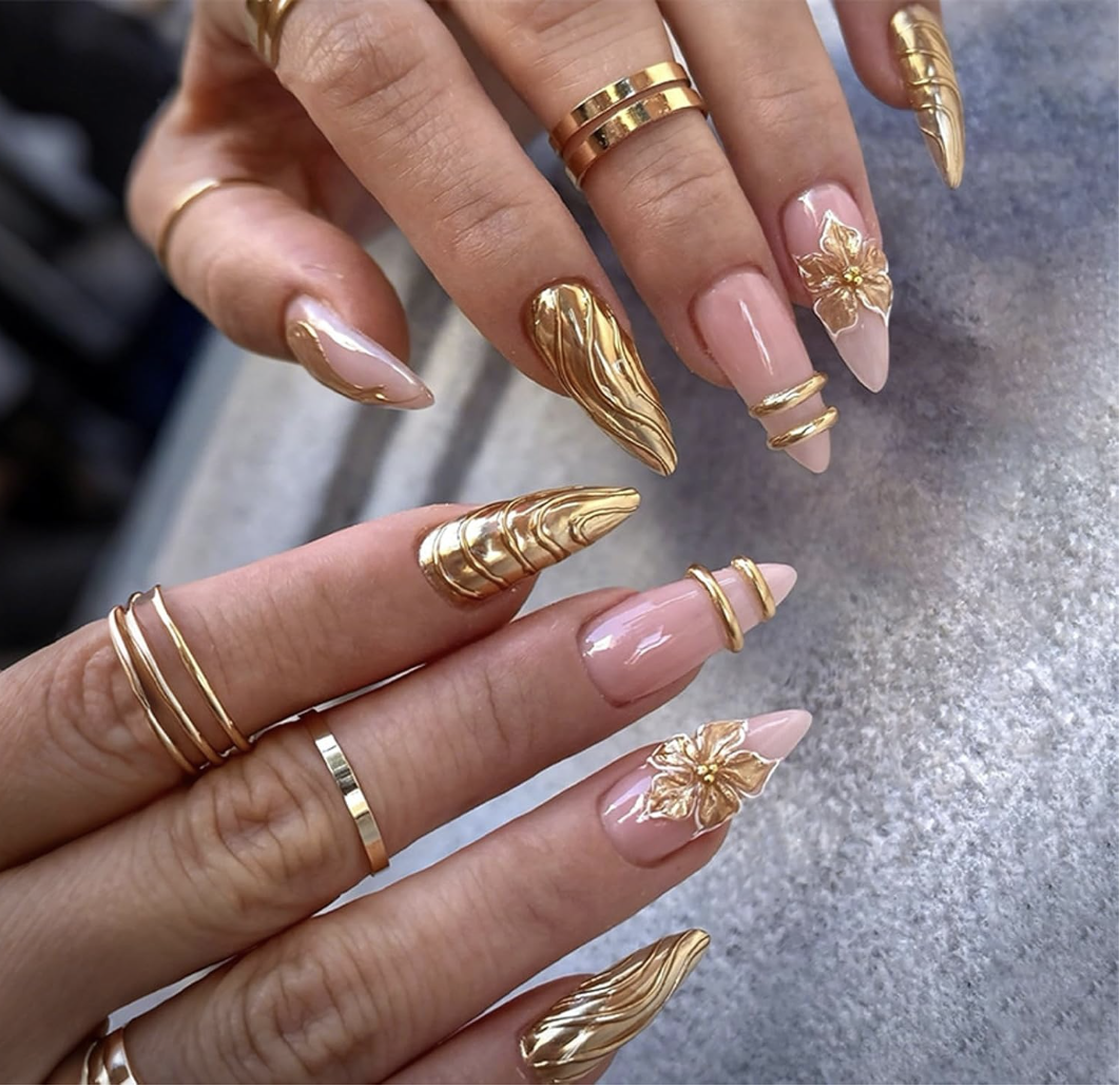 Medium almond-shaped press-on nails with a nude base and intricate gold chrome 3D flower designs.