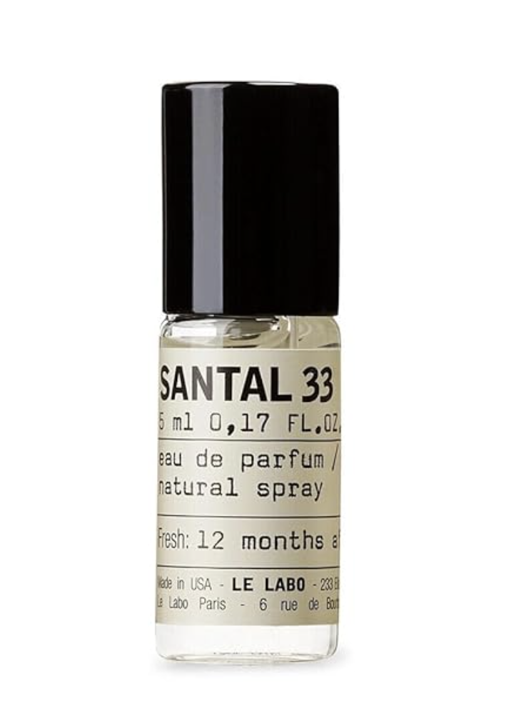 A small travel-sized bottle of Le Labo Santal 33 Eau de Parfum featuring the signature minimalist white apothecary label with black typewriter-style text.