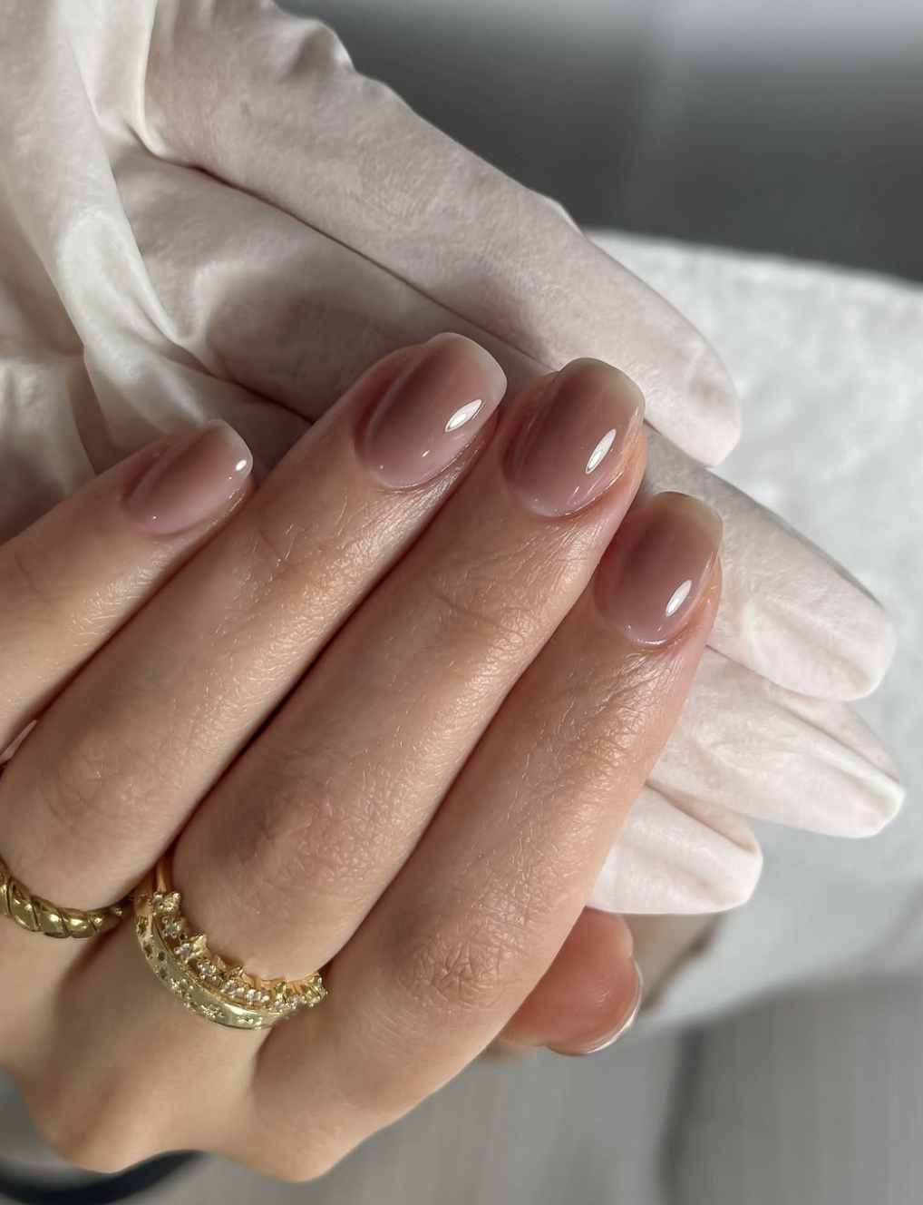 Short rounded nails with translucent espresso-brown polish.